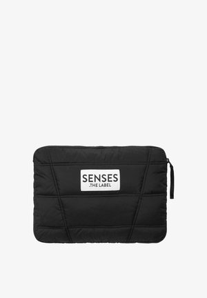 Schwarze gepolsterte Laptop-Hülle mit gesteppter Textur, ausgestattet mit einem weißen Logo-Patch und einem Reißverschluss, entworfen für Schutz und Stil.