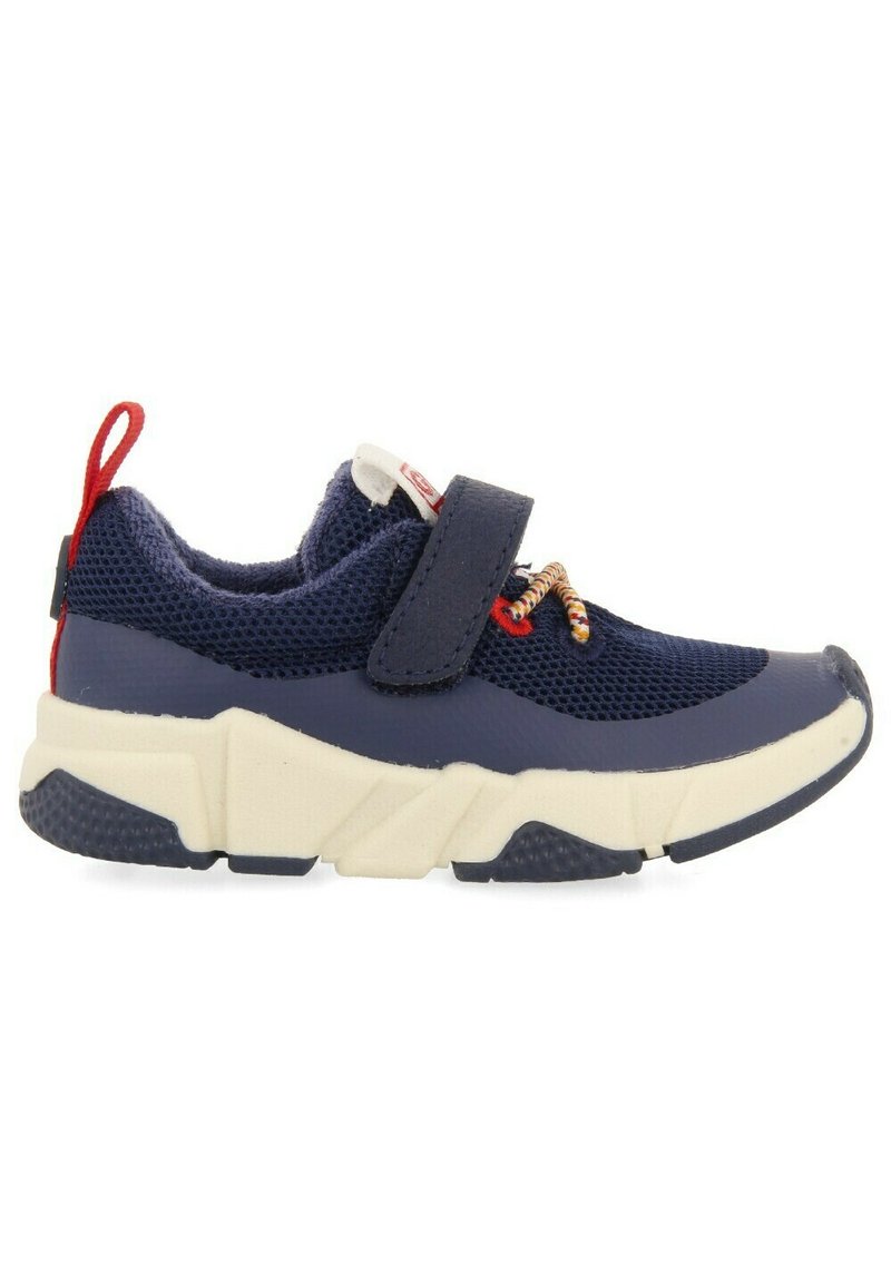 Zapatillas de malla azul con suela crema. Presentan una correa de Velcro, cordones elásticos y una tira roja para tirar. Detalles texturizados en la suela.