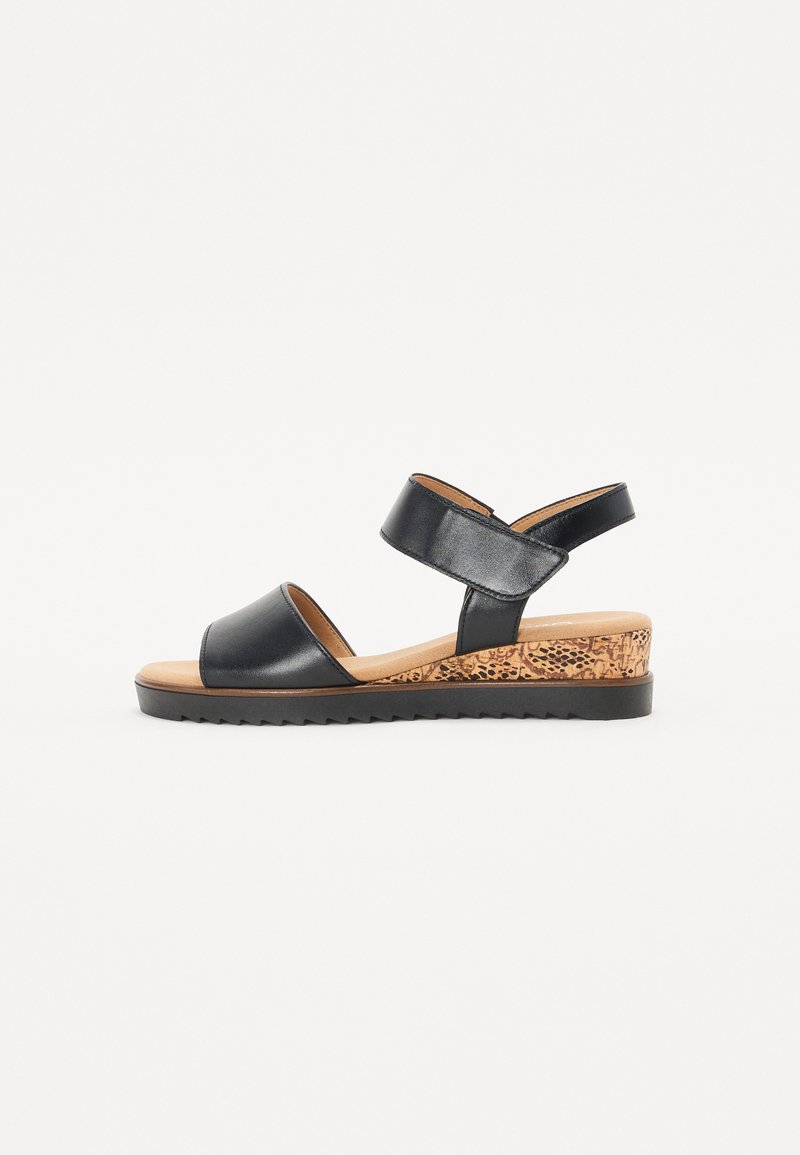 Black leather sandal with two adjustable straps, a rounded toe, and a textured cork wedge heel. Features a sturdy rubber sole.