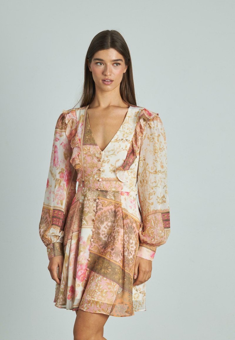 Sukienka ma kwiatowy i wzorzysty design w różowych i złotych odcieniach. Długie rękawy, falbany oraz dopasowany biust z detalami guzików.