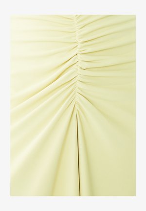 Heled kollane kangas, mille keskel on kokku kogutud detailid, siledat tekstuuri ja vertikaalsed voldid.