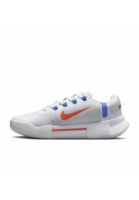 Zapatilla deportiva blanca con upper texturizado, swoosh de Nike en naranja, acentos azules y una suela acolchada. Presenta un patrón de banda de pescado en la suela.