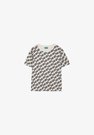T-shirt à manches courtes, col rond en beige clair avec un motif imprimé répétitif de logo noir. Matière en coton doux avec une coupe décontractée.