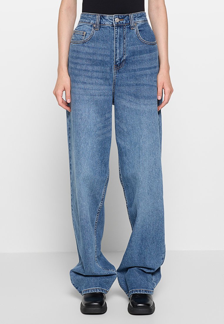 Jean large de couleur bleu clair en denim, avec une taille haute, des poches avant et une finition propre sans embellissements.