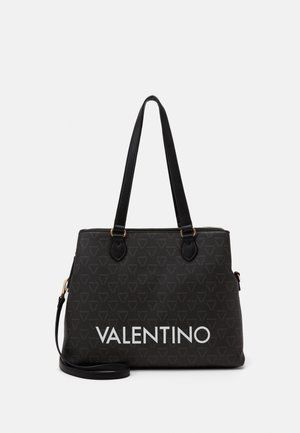 Sac fourre-tout noir avec un motif géométrique texturé, doté de deux poignées, d'une bandoulière amovible et d'un logo "VALENTINO" blanc bien en vue.