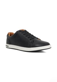 Black leather sneakers with a smooth finish, white rubber sole, and lace-up front. Features a lightly padded tan interior.