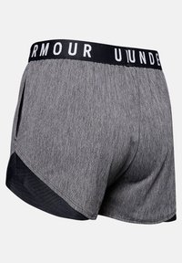 Grå sportshorts med svart kant och elastisk midja som visar delvis vit "UNDER ARMOUR" text, sedd från bakre högra sidan.