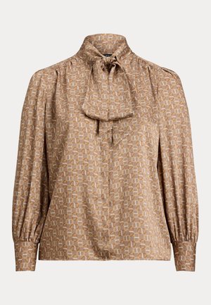 Bluse i lys brun stoff med geometriske mønstre i krem og oransje. Har høy krage med knytebånd og voluminøse ermer.