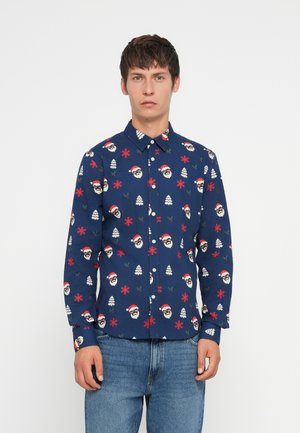 Blaues Langarmshirt mit einem festlichen Muster aus Weihnachtsmann-Gesichtern, Schneeflocken und Bäumen. Hergestellt aus einem Stoff mit glatter Textur und Knopfverschluss.