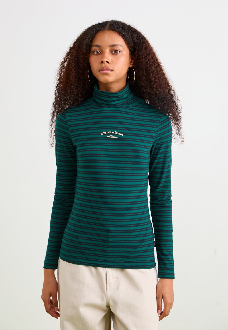 Grøn- og marineblå stribet turtleneck skjorte med lange ærmer, der har et lille gult logo på brystet. Blødt, strækbart stof.