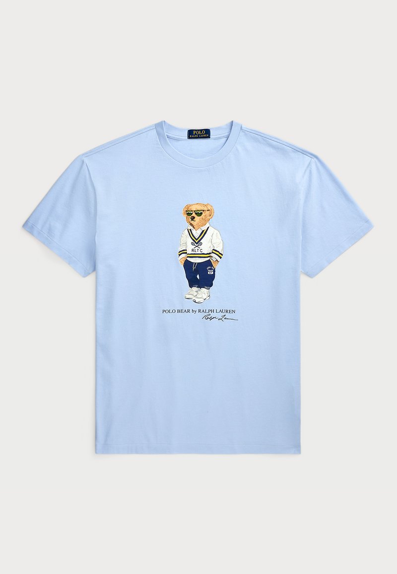 T-shirt en coton bleu clair avec un graphique d'un ours en tenue de sport, portant le texte "POLO BEAR par RALPH LAUREN" en dessous.