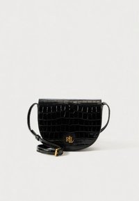 Crna torba od umjetne kože s reljefnim uzorkom krokodilske kože, zaobljenog oblika, s detaljima od zlatnog metala i podesivim remenom. Ima preklopni zatvarač i detalj s logotipom.