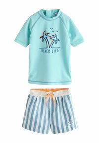 Maglia protettiva a maniche corte azzurro chiaro con grafica di palma e testo "BEACH LIFE", abbinata a pantaloncini da bagno a righe blu e bianche con vita arancione.