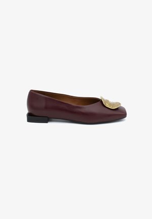 Ballerine in pelle bordeaux con punta arrotondata, dotate di un accent decorativo dorato sulla parte superiore e un tacco basso nero.