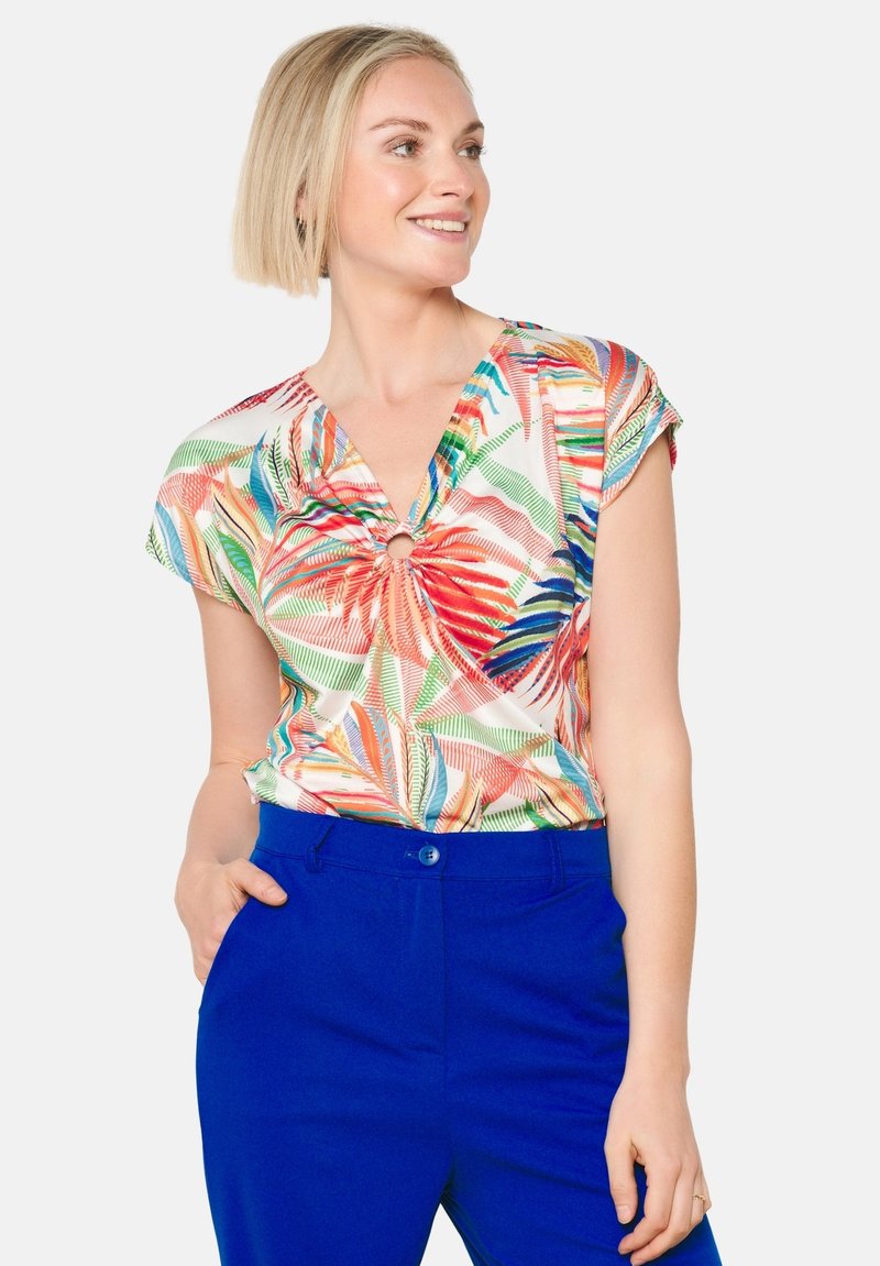 Korte mouwen, veelkleurige blouse met een bloemmotief in rood, groen en blauw. V-hals met een twistdetail in het midden.