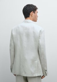 Hellgrauer Leinenblazer mit einem Schlitzausschnitt, Reverskragen und geknöpften Ärmelakzenten. Glatte Textur und minimalistisches Design.
