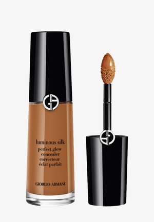 Flacon de correcteur et applicateur avec maquillage liquide marron, bouchons noirs brillants et logo Giorgio Armani sur fond blanc.