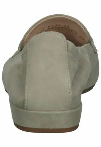 Mocassins en daim gris clair avec un petit talon, texture lisse, dos arrondi et détails de coutures minimales, présentant un design simple sans ornements.