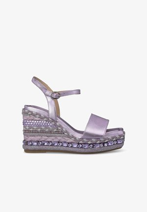 Sandalo con zeppa in lavanda metallico, caratterizzato da un ampio cinturino anteriore, cinturino alla caviglia con fibbia e dettagli intrecciati texturizzati sulla suola.