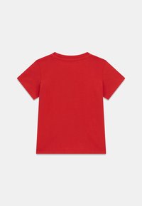 T-shirt en coton rouge à manches courtes, col rond et texture lisse. Présente un design uni sans graphismes ni motifs visibles.