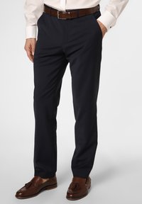 Navy dress pants made from a smooth fabric, tailored fit, with side pockets. Worn with a white shirt and brown leather shoes.
