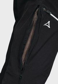 Schwarze Sporthosen mit seitlichem Reißverschluss und Netzfutter sowie einem Logo-Accent. Der Stoff ist glatt mit einem subtilen Glanz.
