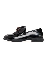 Black patent leather loafers with a flat rubber sole, featuring a large black bow and metallic circular accent on the front.