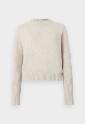 Licht beige cropped sweater van zacht gebreid materiaal, met een ribbelende ronde hals en ribbelmanchetten voor extra textuur. Eenvoudig ontwerp.