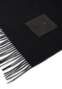 Sciarpa nera realizzata in morbido tessuto, con bordi frangiati e un'etichetta in pelle dalla texture con la scritta "LIU JO dal 1995".