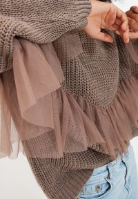 Brązowy sweter dziany z teksturowanym wzorem, z warstwowym, przezroczystym falbaną z tiulu na dole i rękawach dla dodatkowych detali.