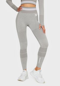 Graue hochtaillierte Leggings mit strukturierter Musterung und horizontalen Streifen. Verfügt über ein figurnahes Design und den Aufdruck "SQUATPROOF" am Knöchel.
