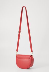 Röd falsk läder axelväska med en böjd form, texturerad klaff, justerbar rem och guldfärgade detaljer.