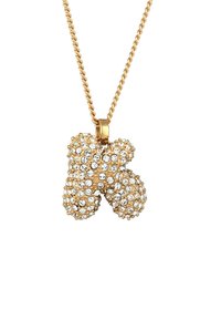 Goldkette mit einem Anhänger in Form eines "K", geschmückt mit zahlreichen klaren Strasssteinen, die eine strukturierte Oberfläche erzeugen.