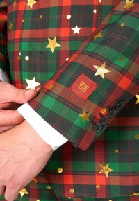 Karierte Blazer in Rot, Grün und Schwarz, verziert mit goldenen Sternen und Punkten. Enthält ein Logo-Patch und schwarze Knöpfe am Ärmel.