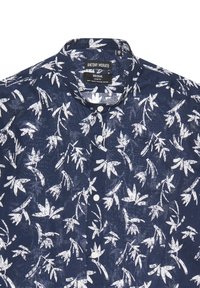 Camicetta a manica corta in cotone navy con stampa botanica bianca, colletto classico e chiusura a bottoni con tre bottoni sul davanti.
