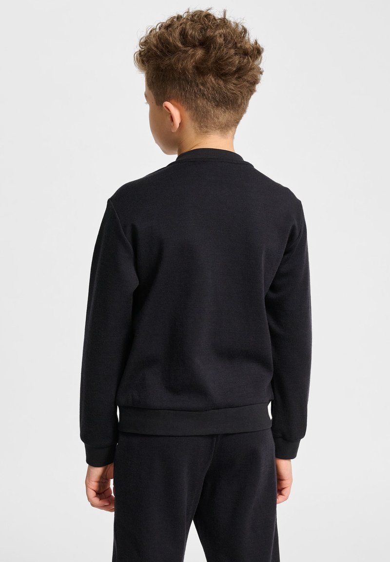 Svart bomullströja med ribbade mudd och nederkant, med rund halsringning och en mjuk textur. Bakifrån syns inga grafik eller logotyper.