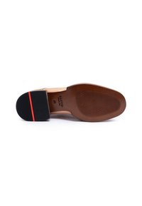 Semelle de chaussure en cuir marron avec un talon en caoutchouc noir et une bande rouge en accent. Surface texturée pour une meilleure adhérence et durabilité.