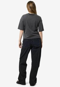 Szara bawełniana koszulka z krótkimi rękawami, luźny krój i okrągłym dekoltem, w zestawie z czarnymi dżinsami prostymi z tylnymi kieszeniami i subtelnym haftem.