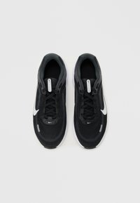 Must-valged mustad ja valged Nike jooksujalatsid, millel on nöörid, valgel taustal, vaadatuna ülalt.