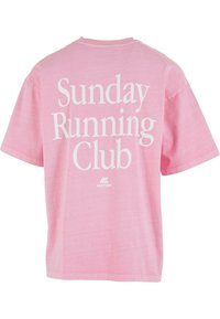 Heled roosa lühikeste varrukatega T-särk, mille seljal on suur valge tekst "Pühapäeva Jooksu Klubi" ja selles all väike brändi logo.