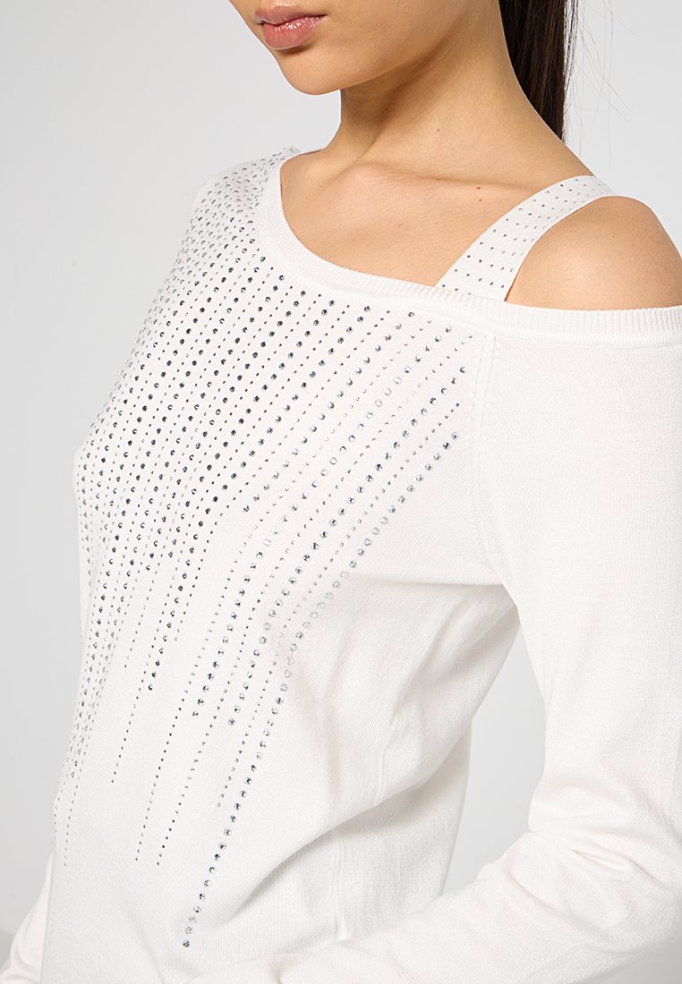 Weißer Strickpullover mit einem schulterfreien Design, verziert mit vertikalen Reihen aus silbernen Strasssteinen, die einen strukturierten Effekt erzeugen.