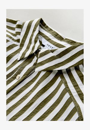 Zaļi un balti svītraina krekla ar izteiktu apkakli un pogu detaļām, izgatavots no viegla auduma ar gludu tekstūru. Redzama zīmola etiķete.