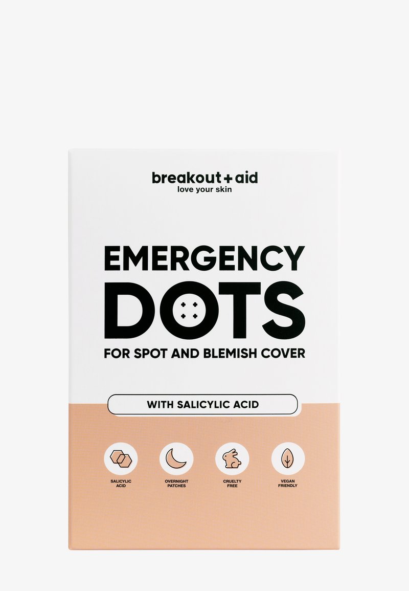 Il packaging di Breakout + Aid Emergency Dots, bianco e pesca chiaro, presenta un testo audace in nero e icone che indicano acido salicilico, cruelty-free e vegan.
