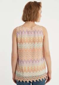 Mouwloos topje met een zigzagpatroon in oranje, roze, lavendel en groene tinten; gestructureerde gebreide stof; golvende zoom.