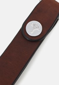 Bracelet en cuir brun avec un bouton métallique argenté arborant un design de palmier, accentué d'une bordure noire pour le contraste et la durabilité.