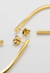 Orecchini in metallo color oro con forme allungate e finitura liscia, con uno stile decorato con piccole pietre trasparenti.