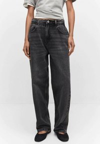 Jeans in denim nero a gamba larga con vita elasticizzata, tasche laterali e leggera scoloritura. Caratterizzati da un classico design a cinque tasche e una vestibilità rilassata.