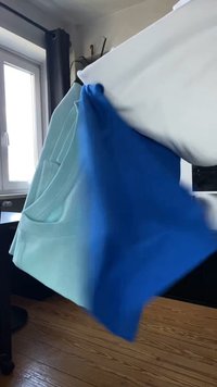 Long-sleeve hoodie featuring a light blue body and blue sleeves, made of soft fabric, with a kangaroo pocket on the front.