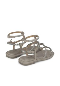 Hellgraue flache Sandalen mit mehreren Riemen-Designs, ausgestattet mit metallischen Akzenten und einer glatten Sohle. Verstellbare Knöchelriemen für zusätzlichen Halt.