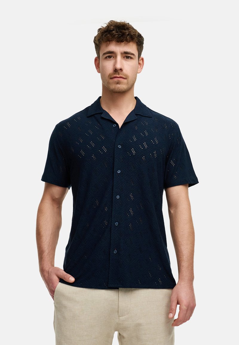 Kortærmet mørkeblå skjorte med en tekstureret åben vævning, knaplukning foran og en klassisk kravedesign. Stoffet virker let.